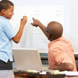 A man and boy are pointing at a whiteboard