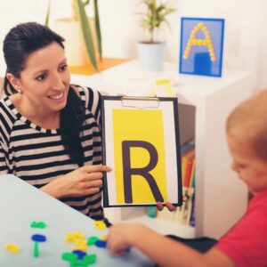 A woman showing a boy how to spell the letter r.